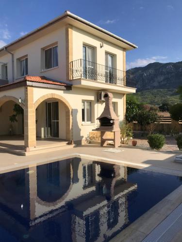 a villa with a swimming pool in front of a house at Casa Santos Kyrenia in Kyrenia