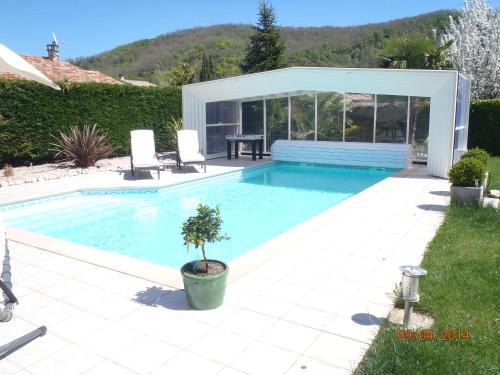 米雷的住宿－L'Olivier Tropical，房屋内带桌椅的游泳池