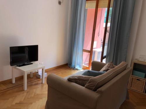 a living room with a couch and a tv at GIOBEA New Aptm with A/C in Monterosso al Mare