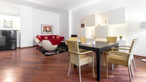 ein Esszimmer und ein Wohnzimmer mit einem Tisch und Stühlen in der Unterkunft Italianway-Cristoforo Colombo in Mailand