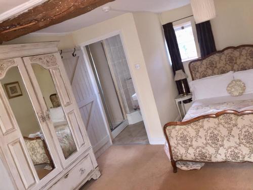 a bedroom with a bed and a mirror at The Three Tuns in Chepstow