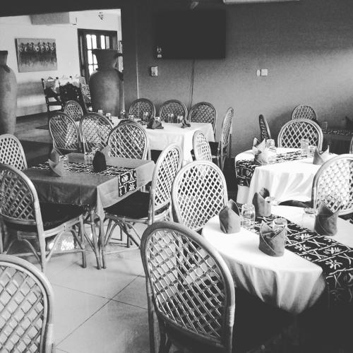 a room filled with tables and chairs with white table cloth at Bojo Beach Resort in Bortianor
