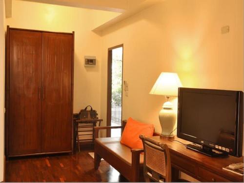 a living room with a large flat screen tv on a table at Sourire at Rattanakosin Island Hotel in Bangkok