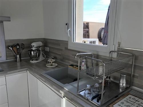 un comptoir de cuisine avec un évier et une fenêtre dans l'établissement 3 Impasse Louis Bassède, à Argelès-sur-Mer