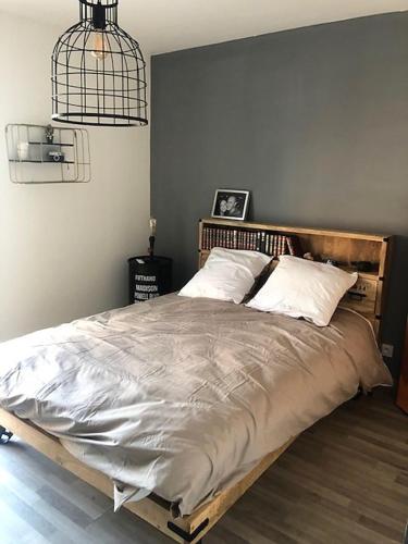 une chambre avec un grand lit avec une tête de lit en bois dans l'établissement 3 Impasse Louis Bassède, à Argelès-sur-Mer