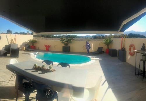 une terrasse avec une piscine, une table et des chaises dans l'établissement 3 Impasse Louis Bassède, à Argelès-sur-Mer