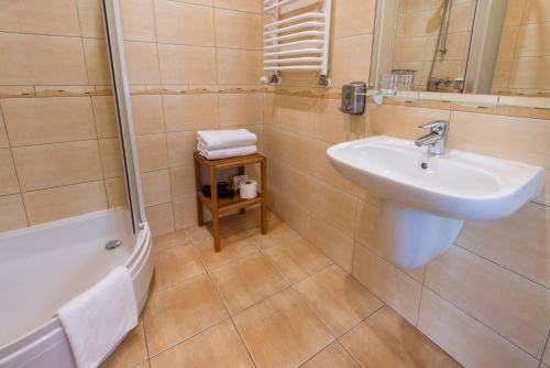 a bathroom with a sink and a toilet and a tub at Dworek 1885 in Ostrzeszów