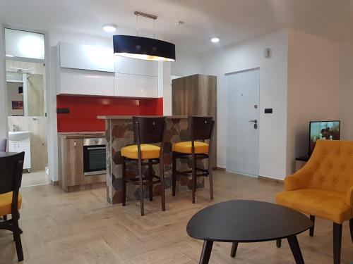 ein Wohnzimmer mit einer Küche mit einem Tisch und Stühlen in der Unterkunft Apartman Simić 2 in Valjevo