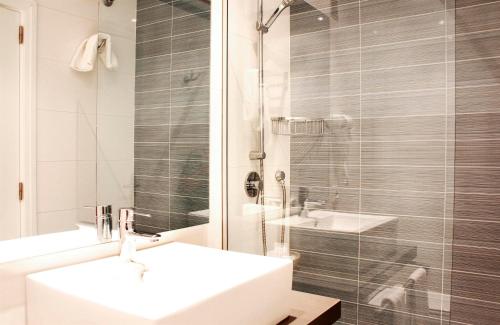 a white bathroom with a sink and a shower at Hotel Bella Playa & Spa in Cala Ratjada