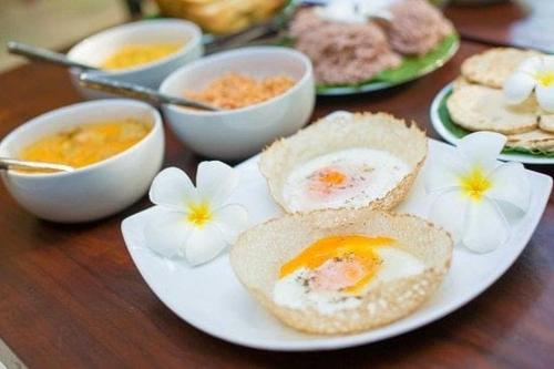 a plate with eggs and other food on a table at The Finz in Hikkaduwa