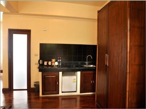 a kitchen with a sink and a counter top at Sourire at Rattanakosin Island Hotel in Bangkok