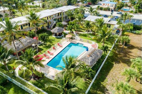 ポンパノビーチにあるOceans Beach Resort & Suitesのプールとヤシの木があるリゾートの空中ビュー