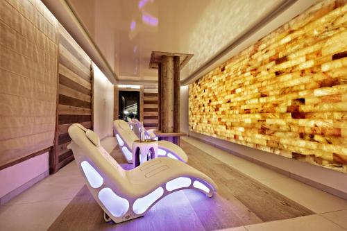 a room with three chairs and a stone wall at MGM Hôtels & Résidences - Hôtel Les Suites d'Alexane in Samoëns