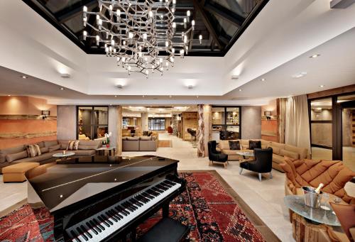 - un salon avec un piano au milieu dans l'établissement Hôtel Alexane, à Samoëns