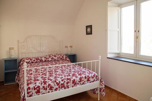 Schlafzimmer mit einem Bett mit einer roten und weißen Tagesdecke in der Unterkunft San Pietro Holiday House in Scala