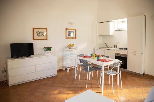 a kitchen with a table and chairs and a television at San Pietro Holiday House in Scala