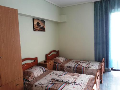 Habitación con 2 camas individuales y ventana. en Tani's Guesthouse, en Ksamil