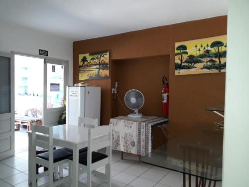 a kitchen with a white table and a refrigerator at Pousada Costa dos Corais in Maragogi