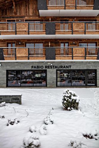 a building with snow on the ground in front of it at MGM Hôtels & Résidences - Hôtel Les Suites d'Alexane in Samoëns