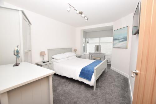 Habitación blanca con cama y lavabo en Number 19, en Bude