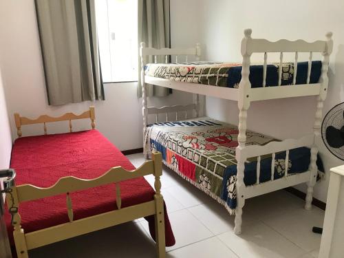 a bedroom with two bunk beds and a small bed at Apartamento São Pedro in São Pedro da Aldeia