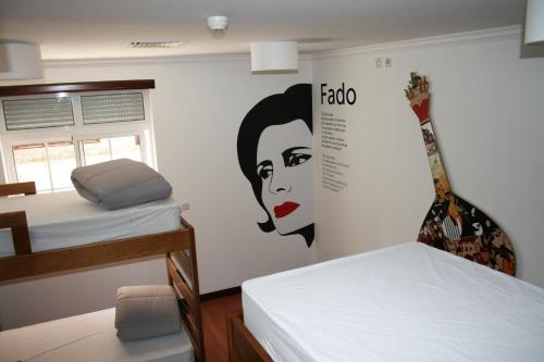 a room with two beds and a guitar on the wall at Hostel 2300 Thomar in Tomar