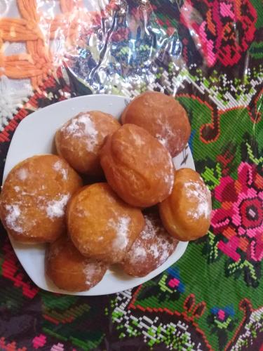 a white bowl of donuts on a table at Pensiunea Valea Branzei in Năneşti