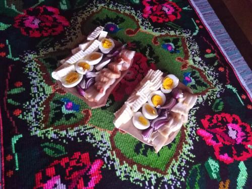 a table with three eggs in egg cartons on a rug at Pensiunea Valea Branzei in Năneşti