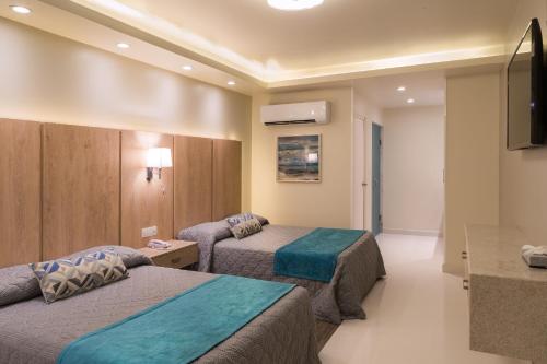ein Hotelzimmer mit 2 Betten und einem Flachbild-TV in der Unterkunft La Siesta Hotel in Hermosillo