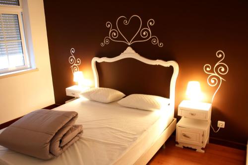 a bedroom with a bed with a headboard and two lamps at Hostel 2300 Thomar in Tomar