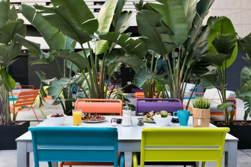 a table with plates of food and colorful chairs at Andante Hotel in Barcelona