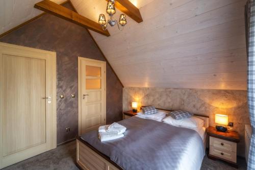 a bedroom with a bed and two night stands and two lamps at u kowola in Szaflary