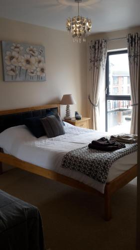 sypialnia z łóżkiem z żyrandolem i oknem w obiekcie River view Apartment w mieście Stourport