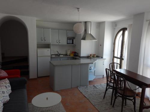 cocina y sala de estar con mesa y sillas en ADOSADO EN NERJA URB FLAMINGO, en Nerja