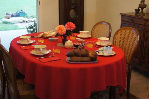 a table with a red table cloth with food on it at Acaba d'Entrar in Le Caylar