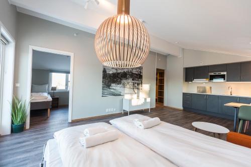 a bedroom with a large bed and a large chandelier at MAYA Apartments - Kasjotten in Lillestrøm