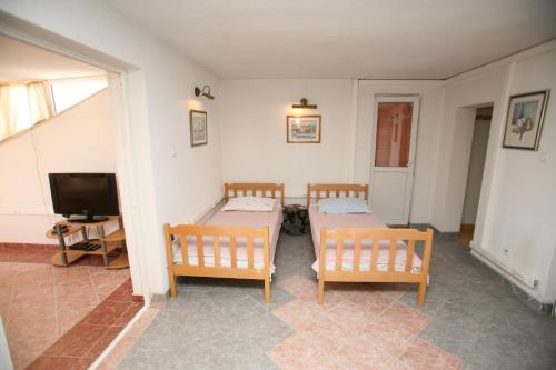 a living room with two beds and a television at Villa Marija in Trogir