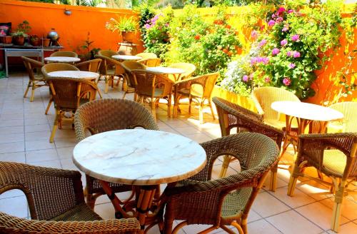 a dining area with tables, chairs, and tables with umbrellas at Hotel Savoy in Rhodes Town