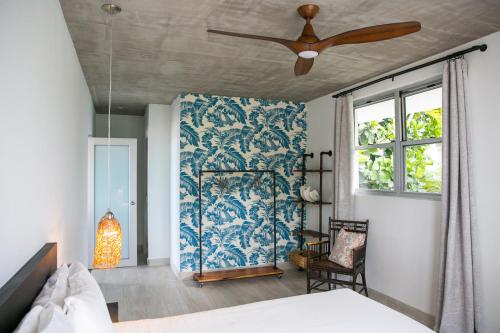 a bedroom with a bed and a ceiling fan at Numero Uno Beach House in San Juan