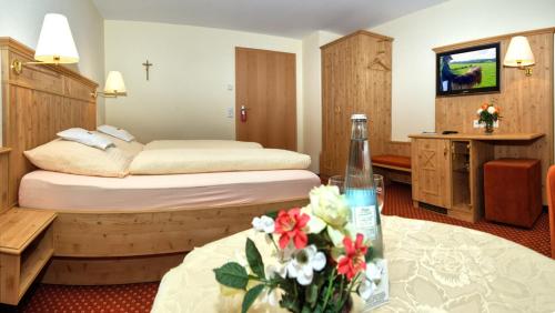 a hotel room with two beds with flowers on a table at Gasthaus Sonne in Münstertal