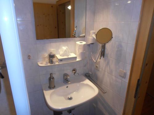 a bathroom with a sink and a mirror at Restaurant Olympia & Apartments in Bergen