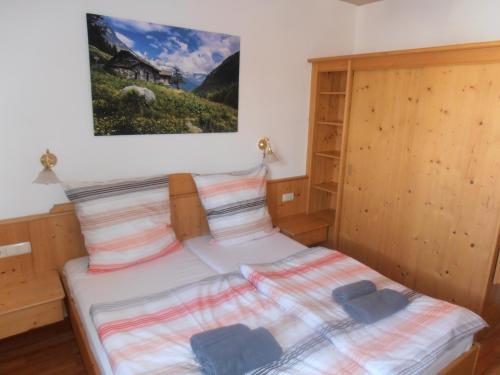 a bedroom with a bed with a picture on the wall at Restaurant Olympia & Apartments in Bergen