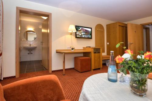 a hotel room with a table and a bathroom at Gasthaus Sonne in Münstertal