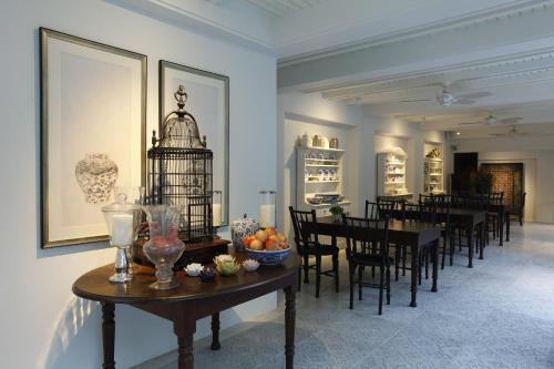 a dining room with tables and a bird cage on the wall at Makka Hotel in Chiang Mai