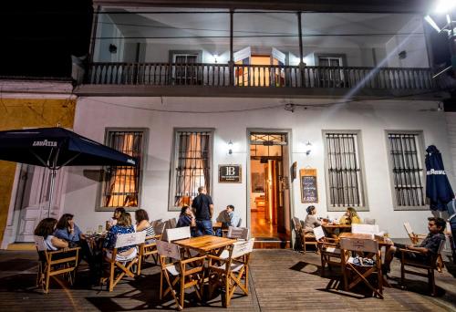 a group of people sitting at tables in front of a building at Hotel Baquedano Boulevard in Iquique