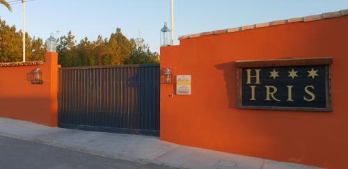 an orange fence with a gate with a sign that reads iris at Hotel Iris La Eliana in La Eliana