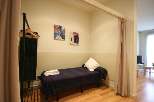 Habitación pequeña con cama y cortina en Az Barcelona Center, en Barcelona