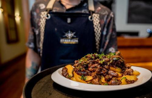 a person holding a plate of food on a table at Hotel Baquedano Boulevard in Iquique