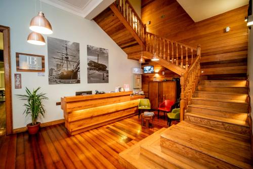 a lobby with wooden stairs and a stair case at Hotel Baquedano Boulevard in Iquique