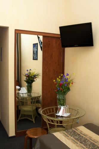 a room with a mirror and a table with flowers at Wien Hotel in Lviv